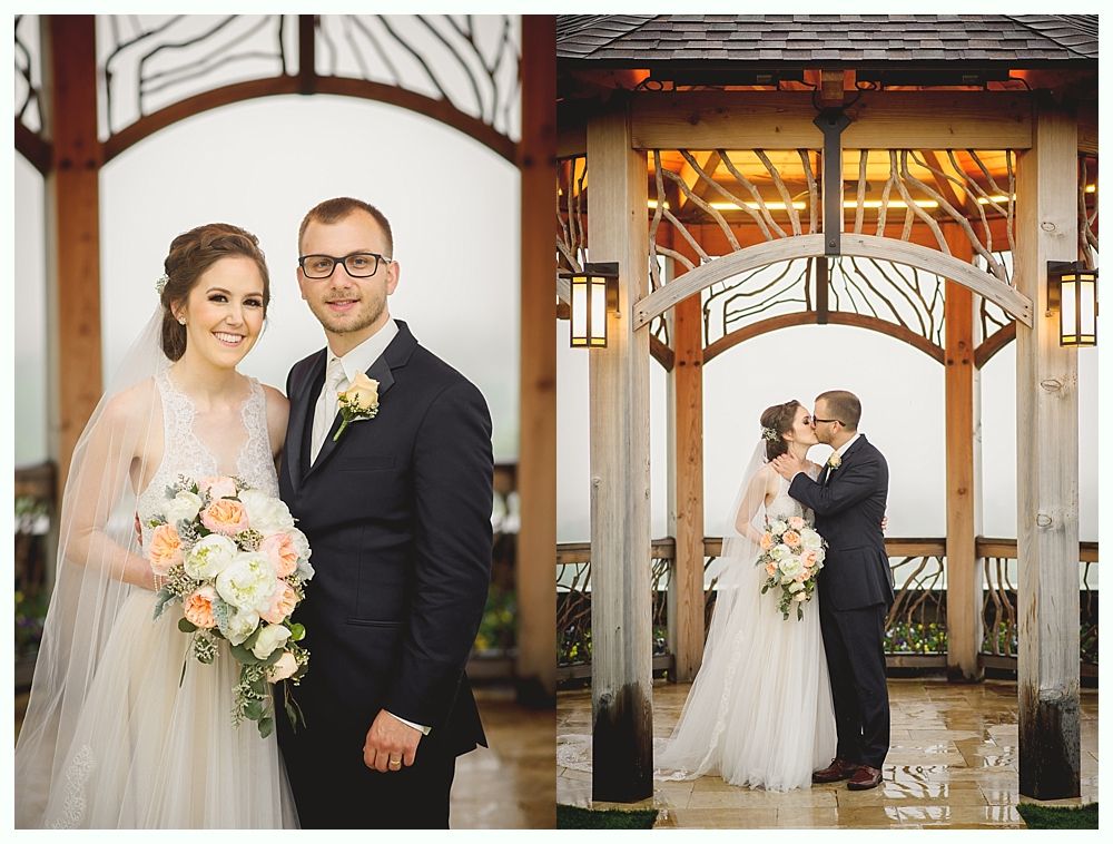 Wedding couple posing under a wooden archway, the bride smiling, the groom in a suit.