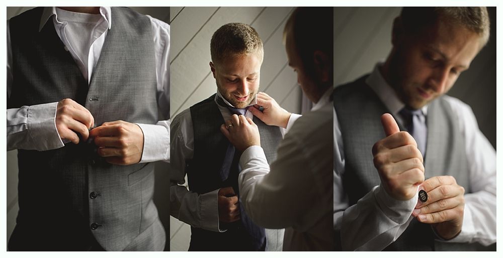 Man in vest and dress shirt adjusting tie and cufflinks.