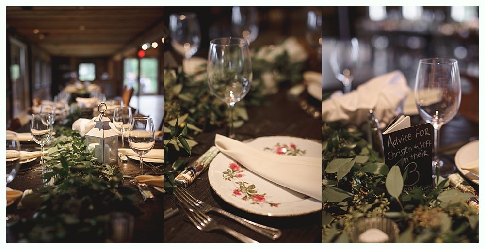 Formal table setting with greenery, wine glasses, and floral plates, ready for a gathering.