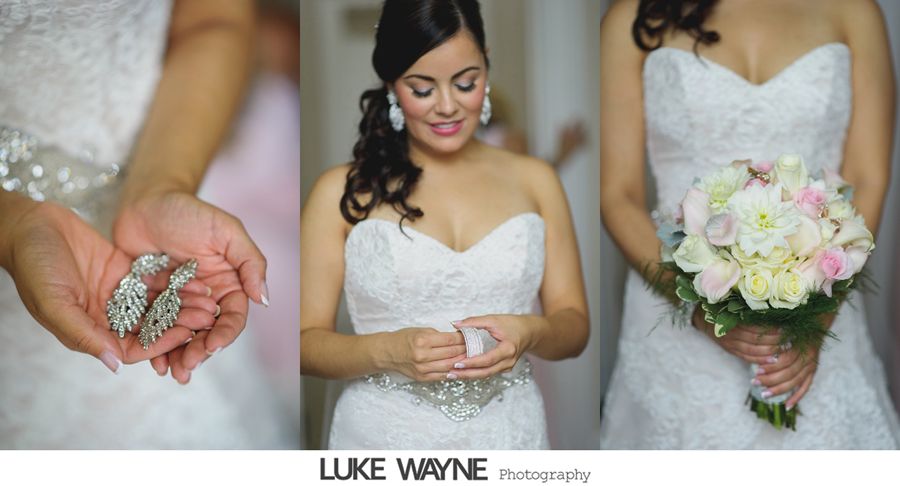 Bride in white wedding dress holding earrings and bouquet, getting ready for the ceremony.