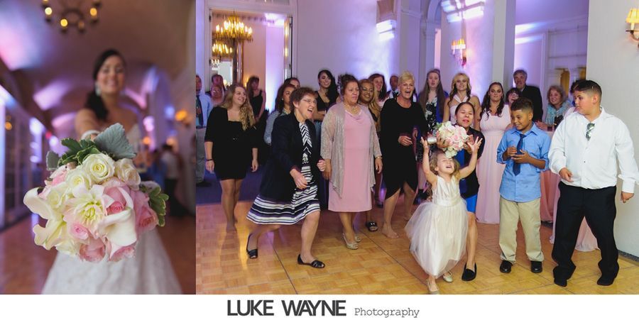 Bride throws bouquet at wedding reception. Guests gather on the dance floor in a well lit room.
