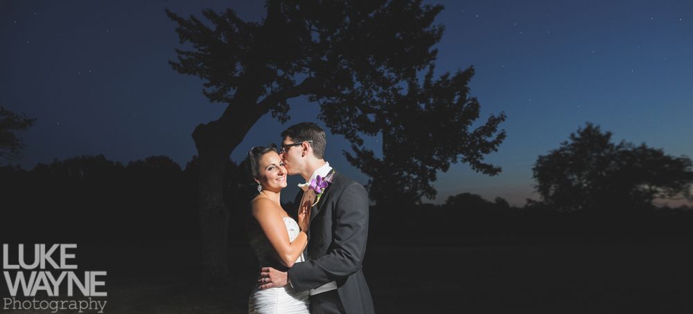 Woman smiles while gazing at man with his arm around her.