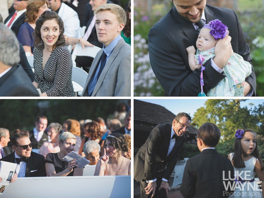 Couple embracing, smiling in front of a tall stone tower with cloudy sky background.