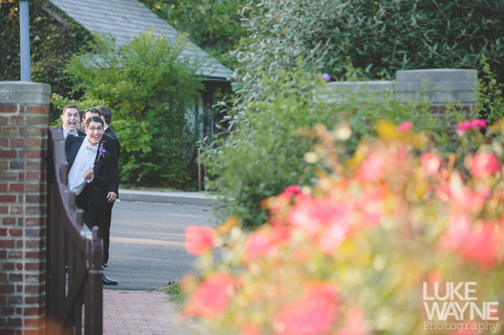 Couple embracing at sunset; man in green shirt, woman in denim jacket and red dress, with blowing hair.