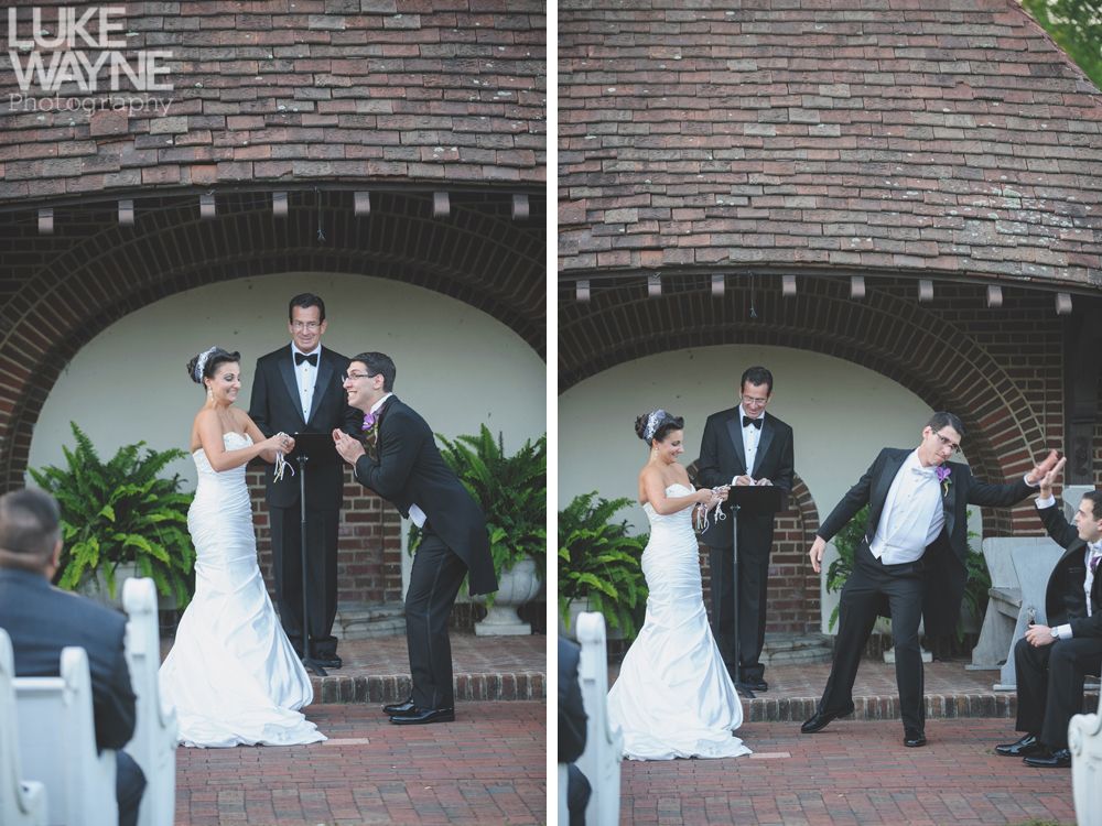 Couple embracing at sunset; man in green shirt, woman in denim jacket and red dress, with blowing hair.