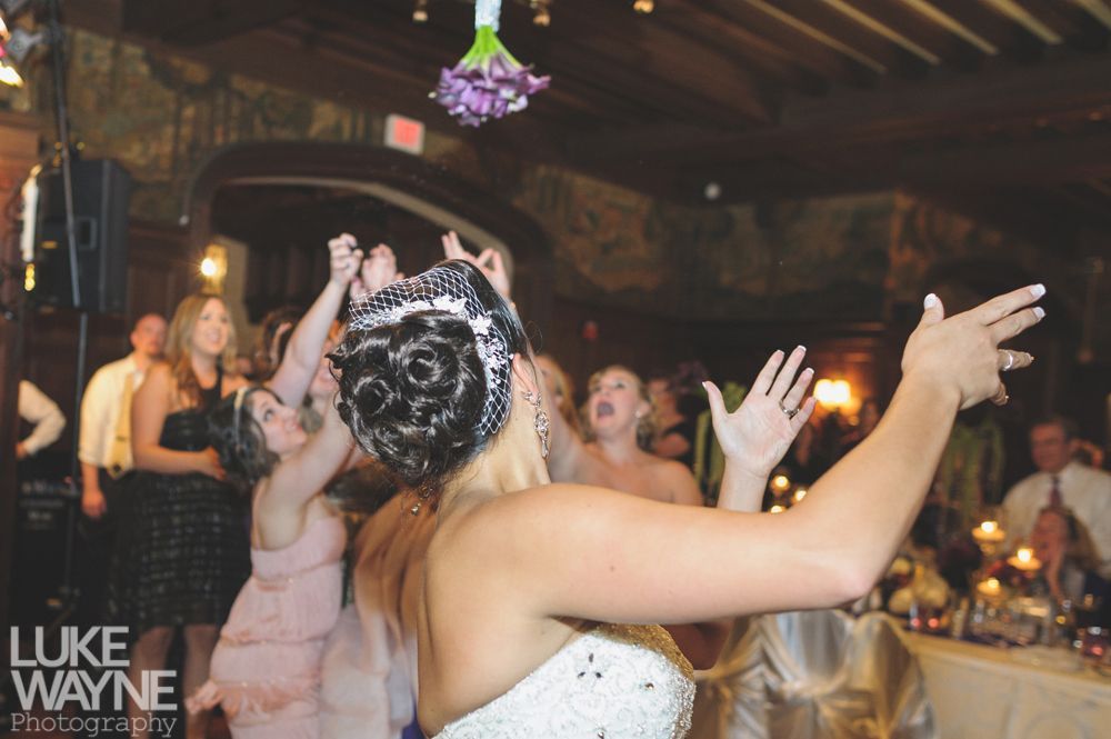 Couple embracing at sunset; man in green shirt, woman in denim jacket and red dress, with blowing hair.