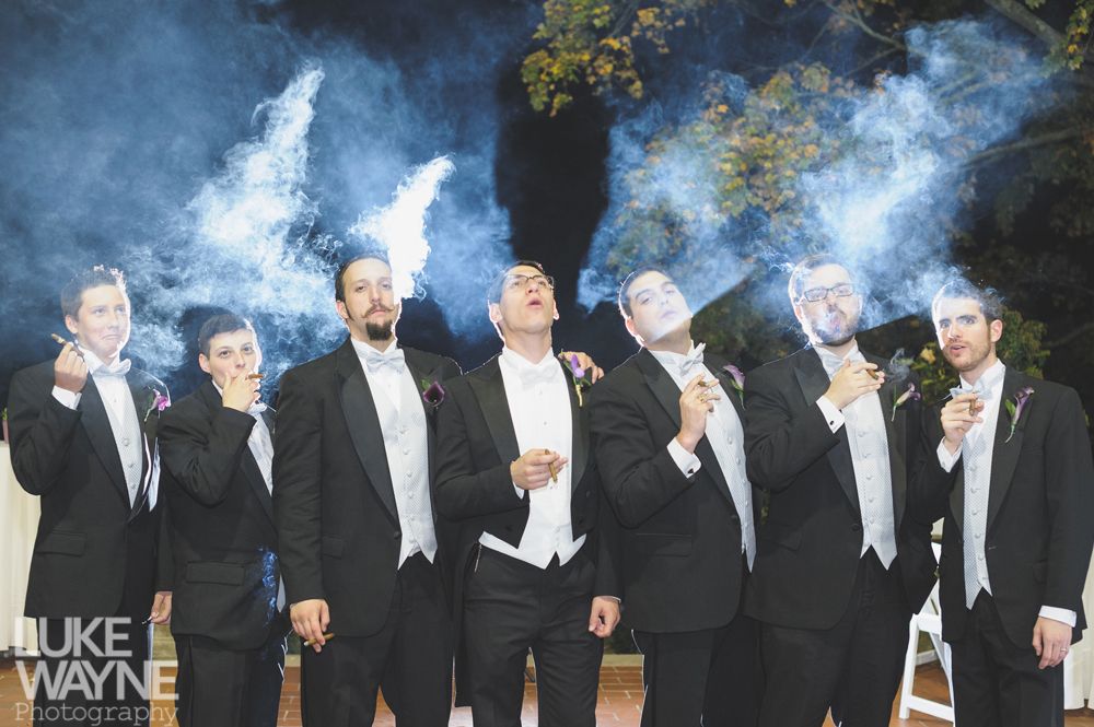 Couple embracing at sunset; man in green shirt, woman in denim jacket and red dress, with blowing hair.