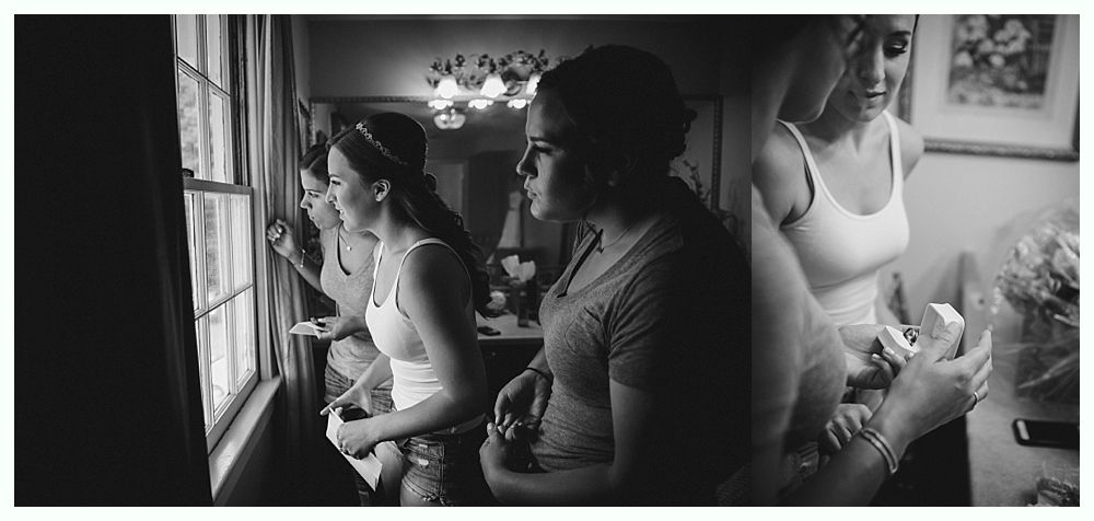 Couple on boardwalk by ocean, framed by beach plants under a blue sky with clouds.