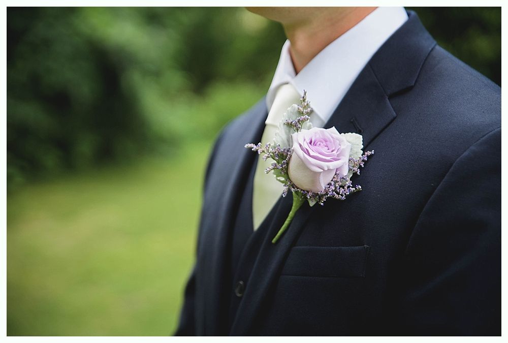 Bride with arms up, making a funny face, groom looking at his hand, cake cutting in background.