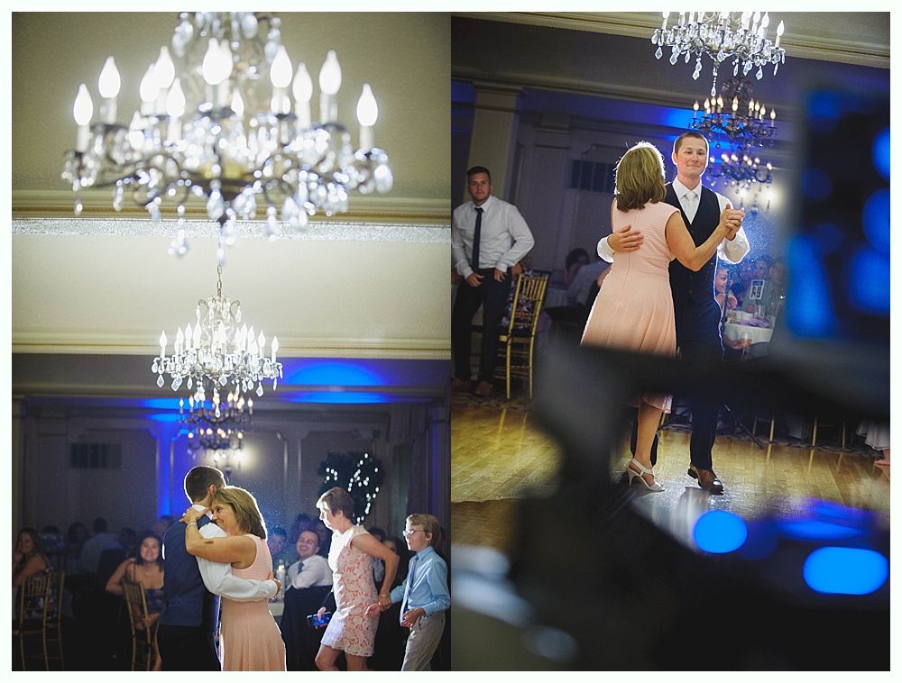 Bride with arms up, making a funny face, groom looking at his hand, cake cutting in background.