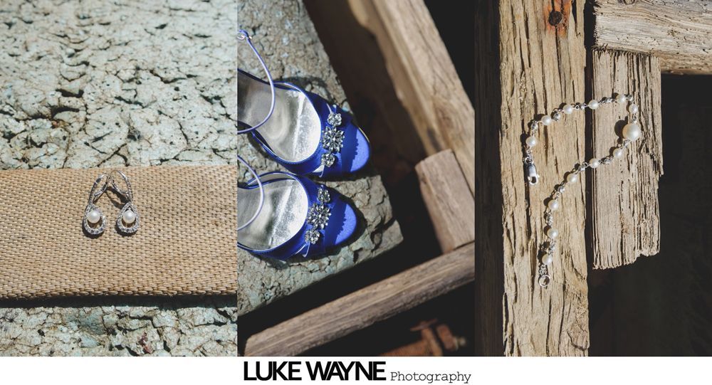 Wedding accessories: blue shoes, earrings, pearl bracelet, and woven clutch on rustic wooden boards.