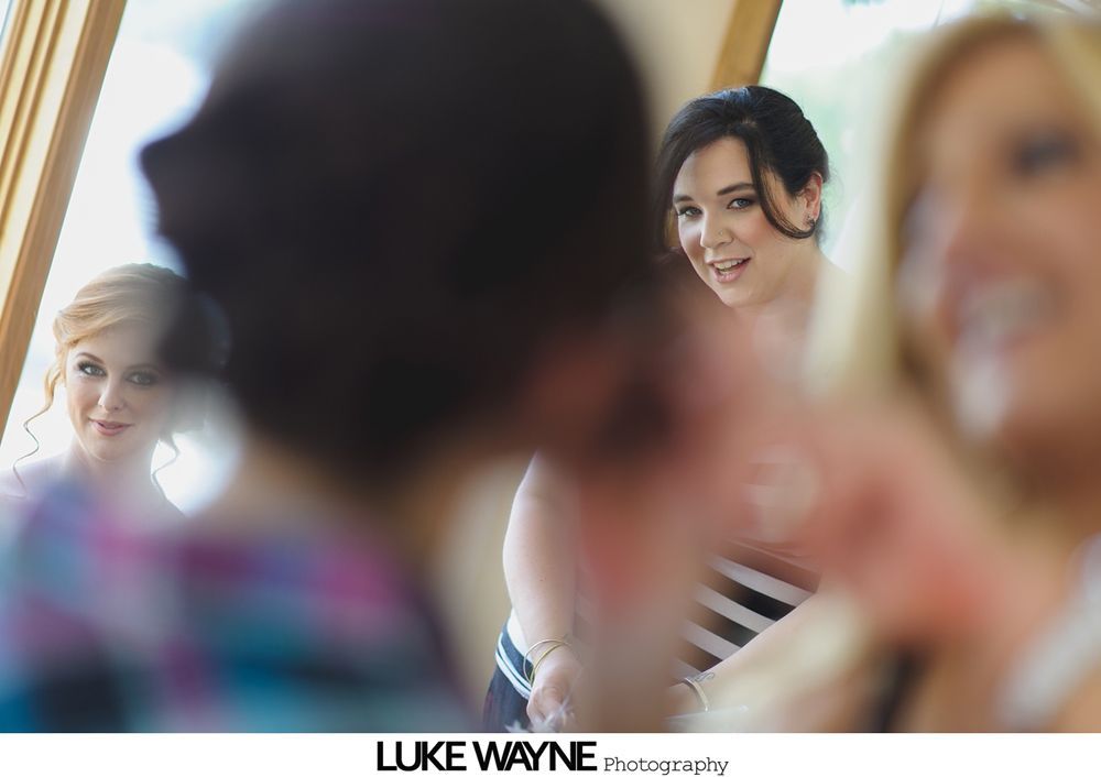 Three women in a room, two looking towards the camera, the third out of focus.