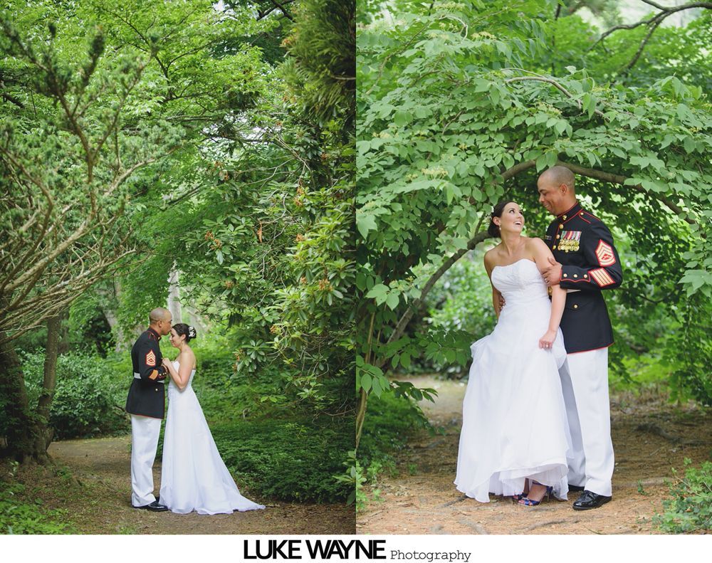 Wedding couple: Marine in uniform, bride in white gown, surrounded by greenery. They're embracing and smiling.