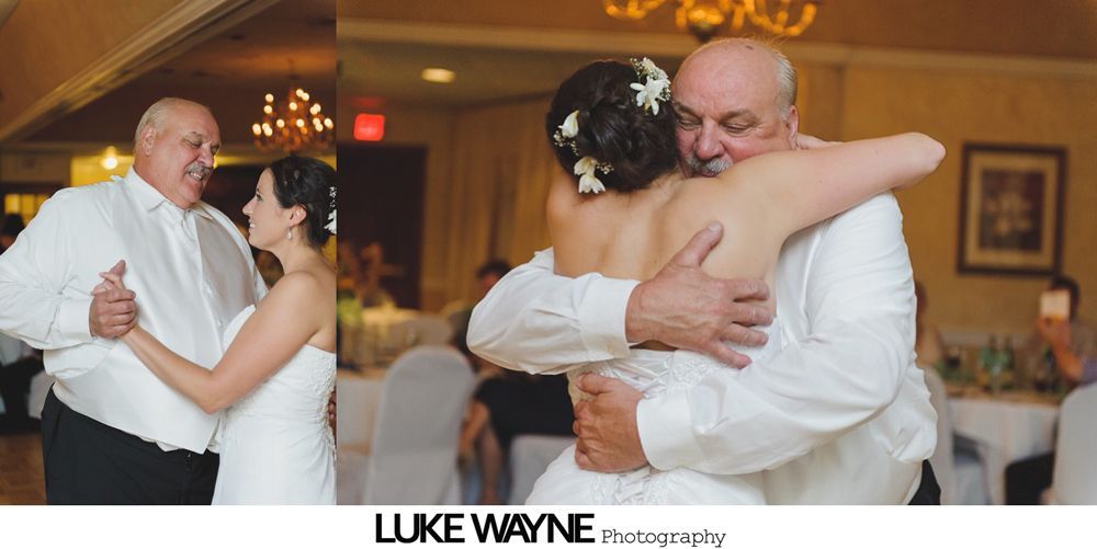 Bride and father dancing at a wedding reception. They hug and smile while enjoying the special moment.