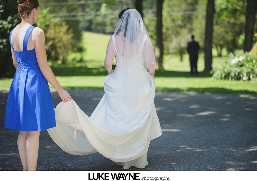 Bridesmaids posing for a group photo in a garden, holding bouquets and smiling.