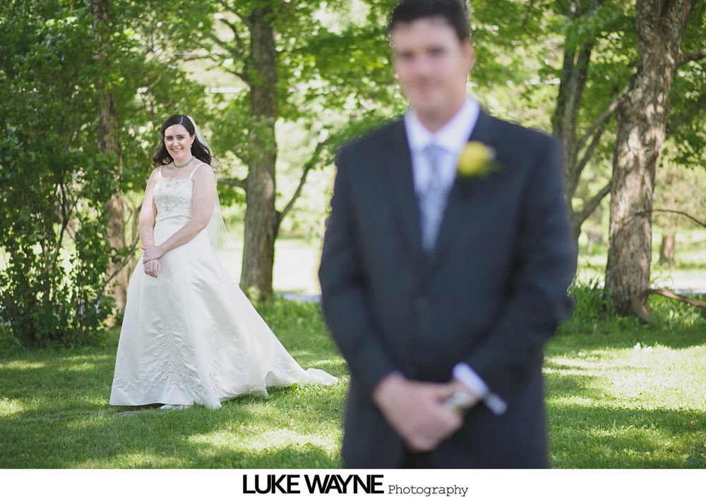 Wedding sign on an easel, surrounded by flower arrangements on chairs.