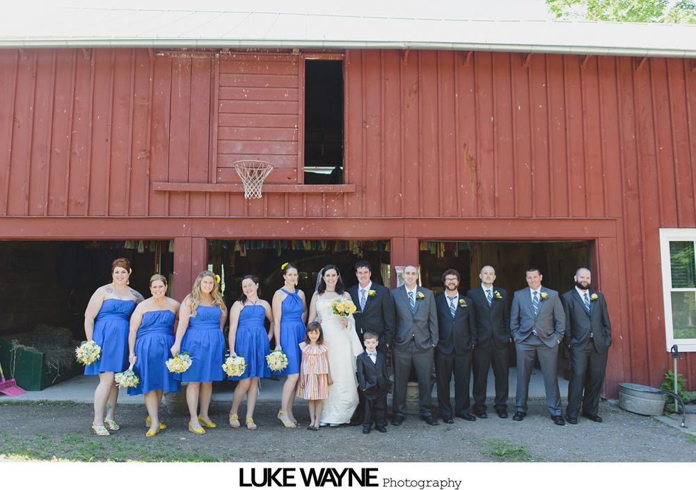 Couple kissing at their wedding ceremony inside a glass-roofed structure, surrounded by guests.