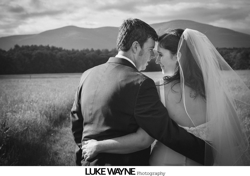 Wedding party carrying bride indoors with paper lanterns.
