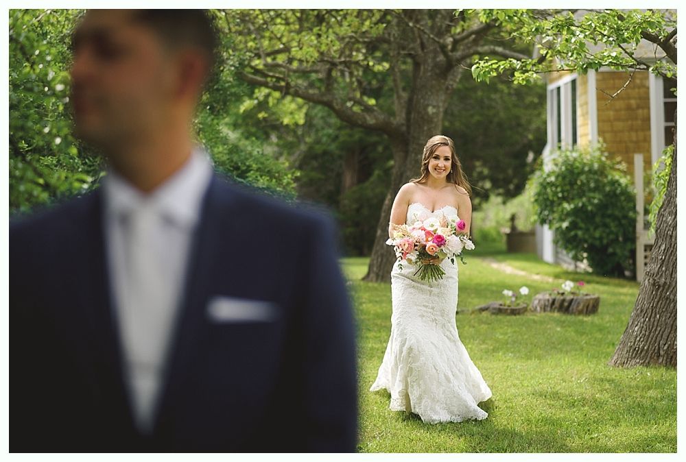 Bride and bridesmaids posing in a garden, all wearing dark blue dresses and holding bouquets.