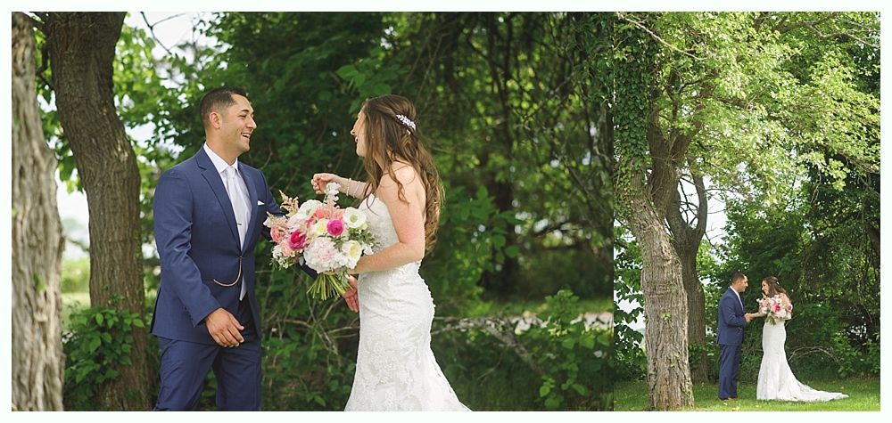 Bride and bridesmaids in navy dresses playfully lift skirts, laughing in a grassy setting.