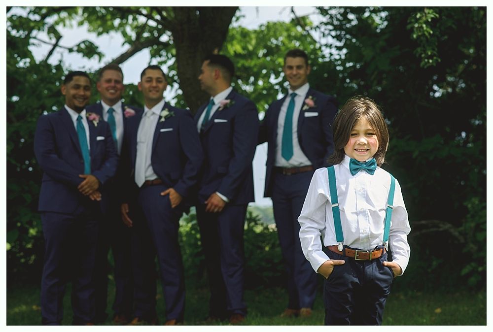 A groom in a gray suit and a bride holding a bouquet of flowers.