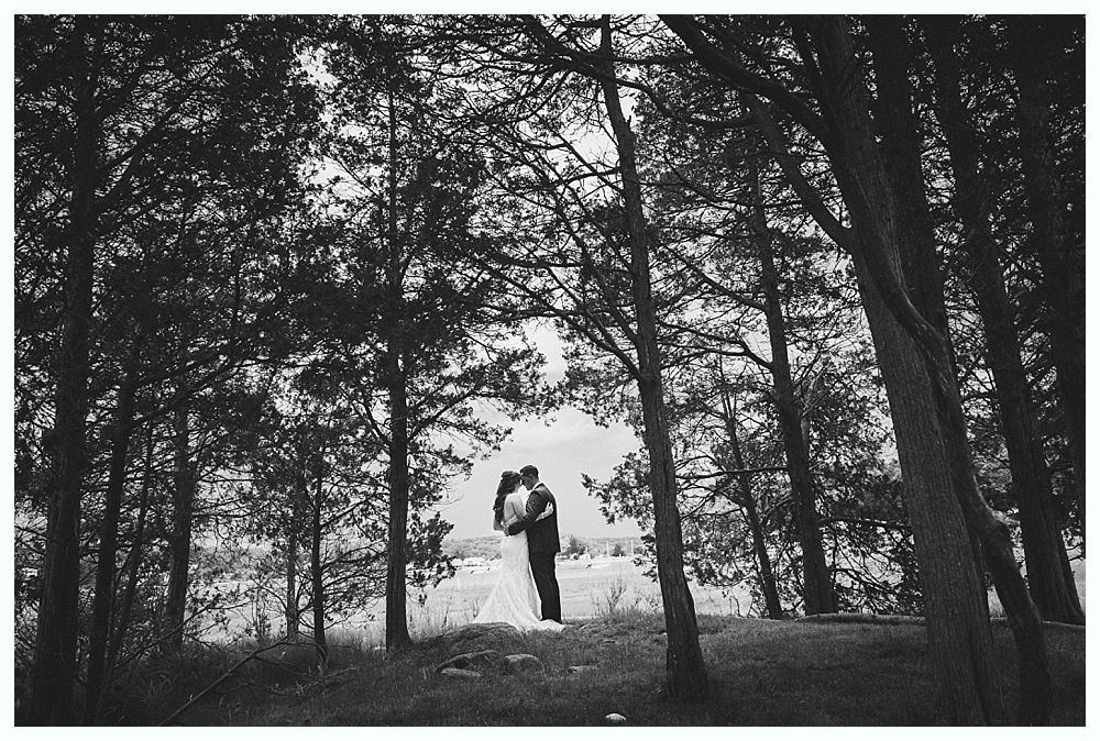 Wedding couple kissing in front of a red barn.