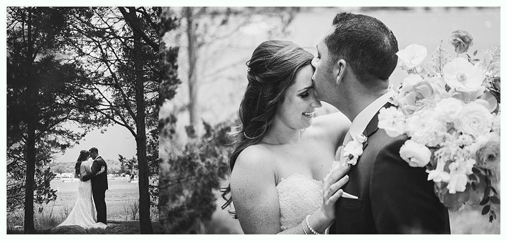 Bride and groom holding hands, exiting red barn. The couple smiles on steps with flowers.