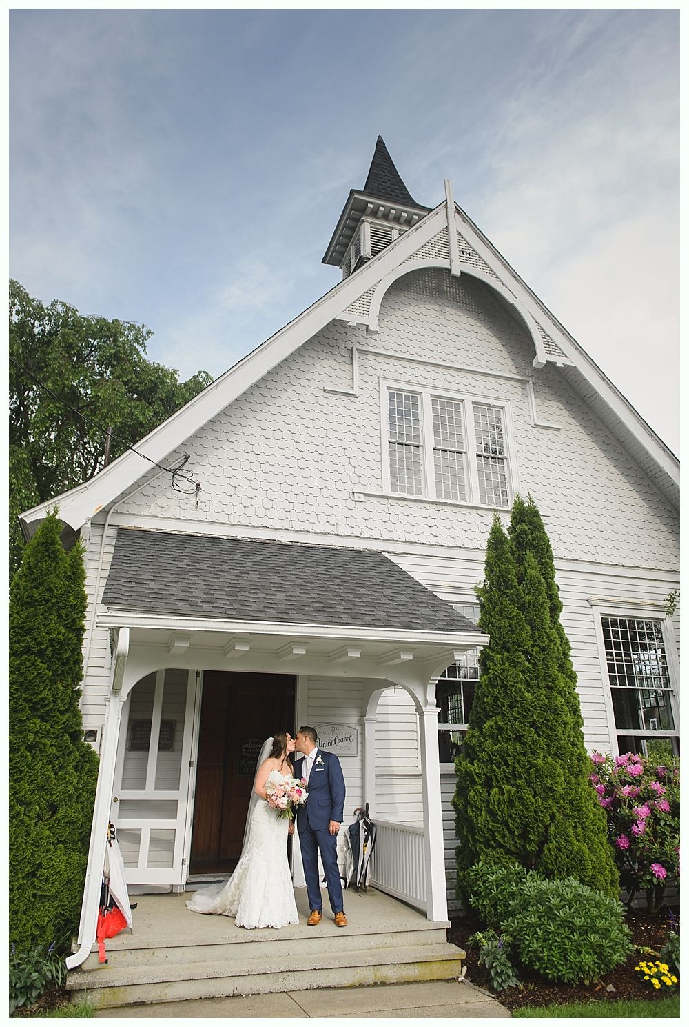Wedding reception setup with cake, cupcakes, and decorated tables in a wood-beamed hall.