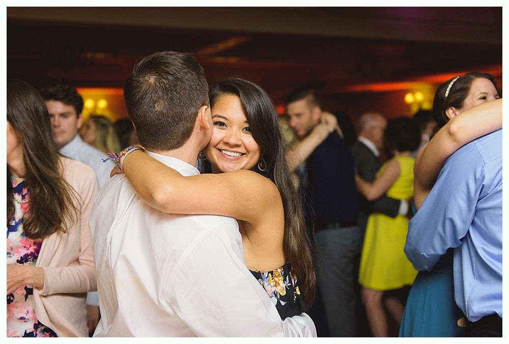 Couple kissing on steps of red building at dusk; backlit, dramatic lighting.