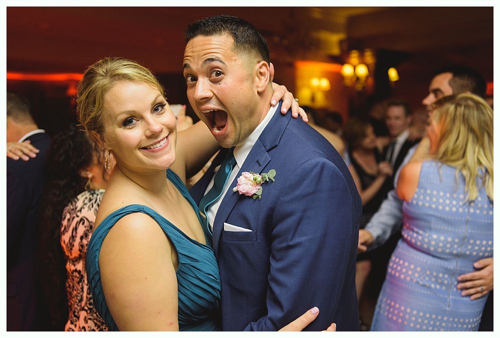 Couple kissing on steps of red building at dusk; backlit, dramatic lighting.