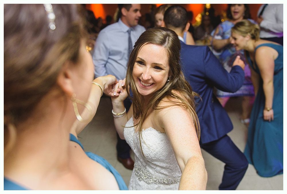 Couple kissing on steps of red building at dusk; backlit, dramatic lighting.