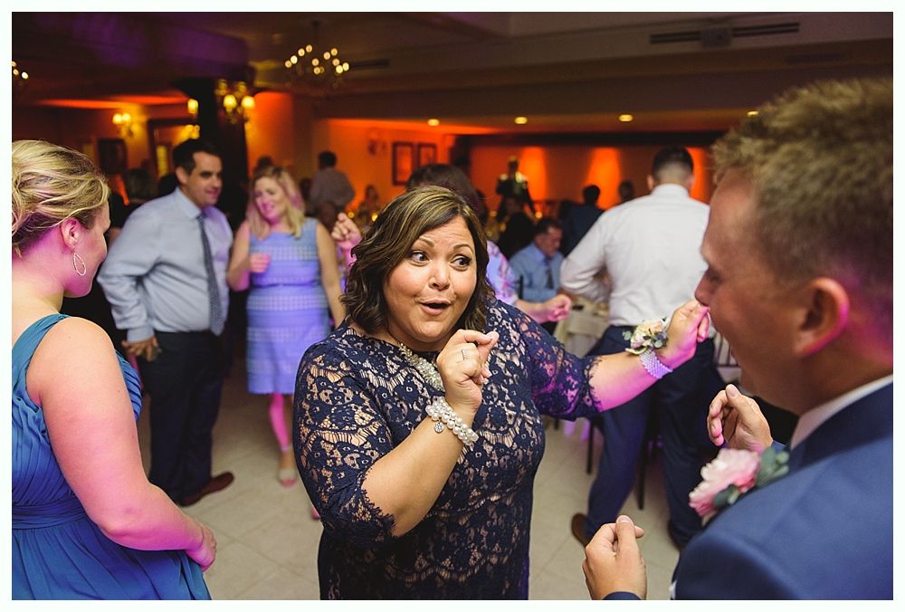 Couple kissing on steps of red building at dusk; backlit, dramatic lighting.