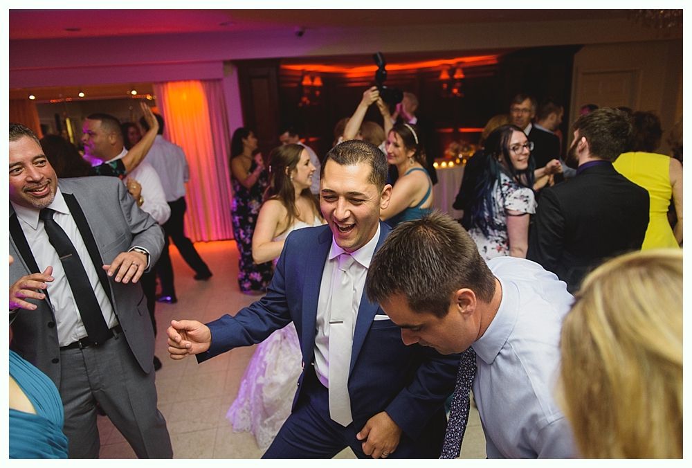Couple kissing on steps of red building at dusk; backlit, dramatic lighting.