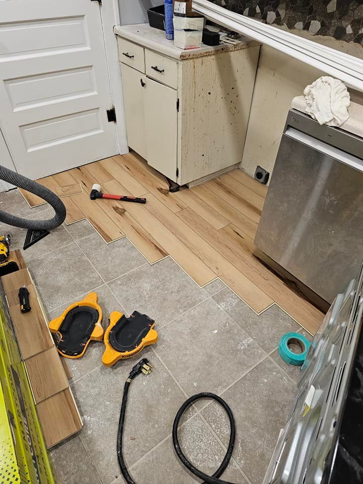 A kitchen with wooden floors and a stainless steel dishwasher.