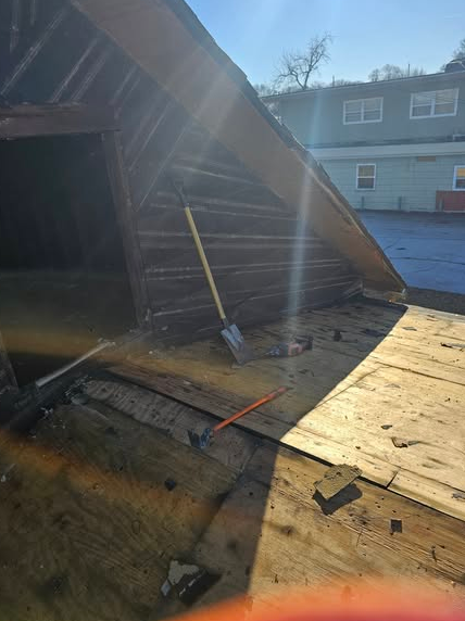A shovel is sitting on the roof of a building.
