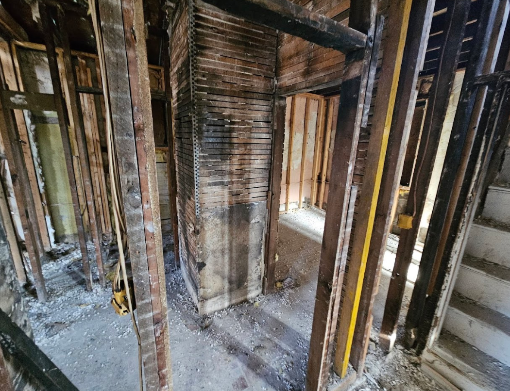 A building under construction with wooden beams and stairs.
