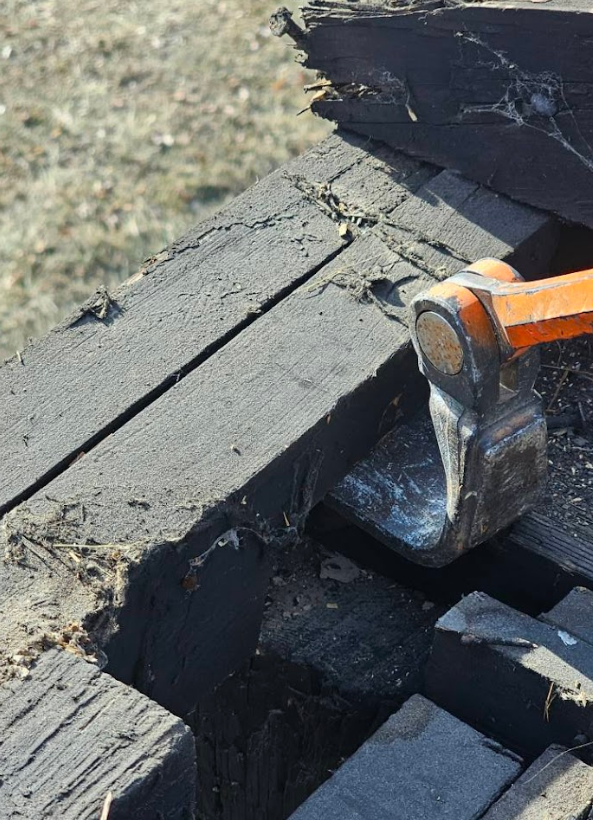 A hammer is being used to break a piece of wood.