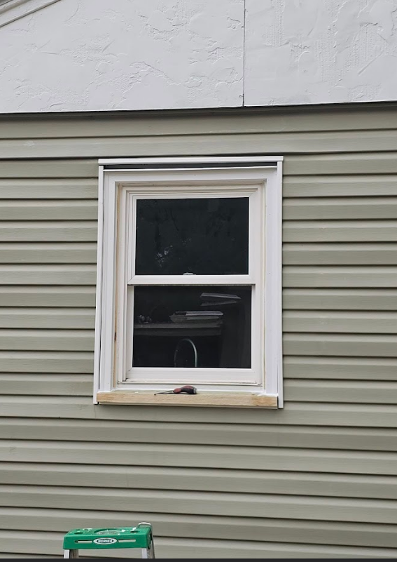 A window is being installed on the side of a house.