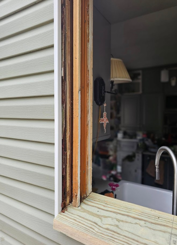 A window on a house with a lamp hanging from it