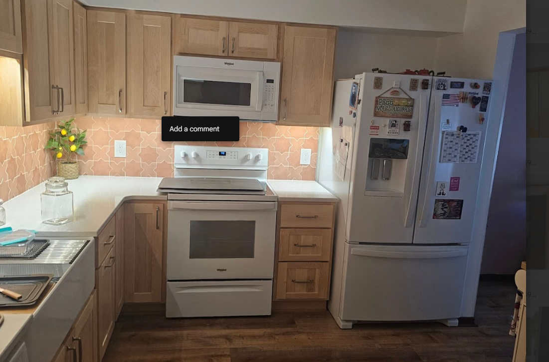 A kitchen with a stove , refrigerator , microwave and sink.