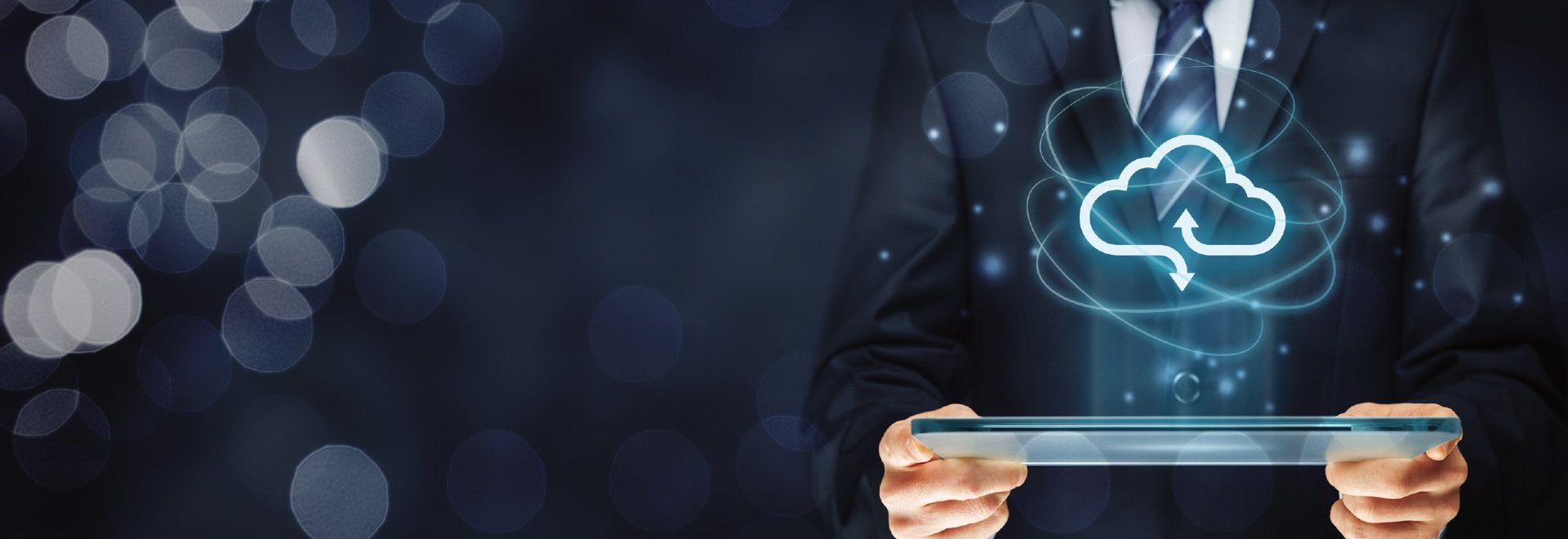 A man in a suit and tie is holding a tablet with a cloud coming out of it.