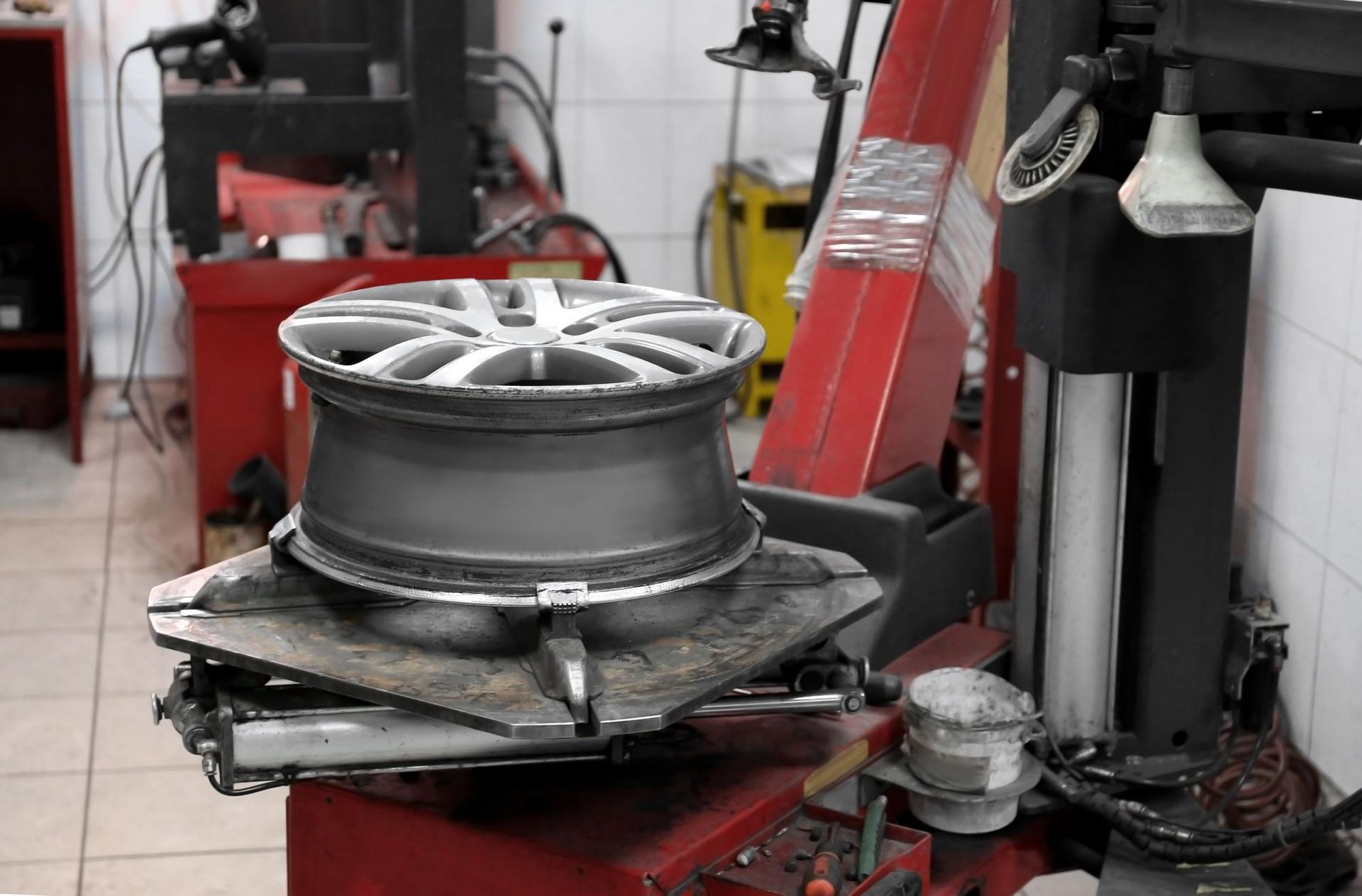 A person is spraying paint on a wheel in a factory.