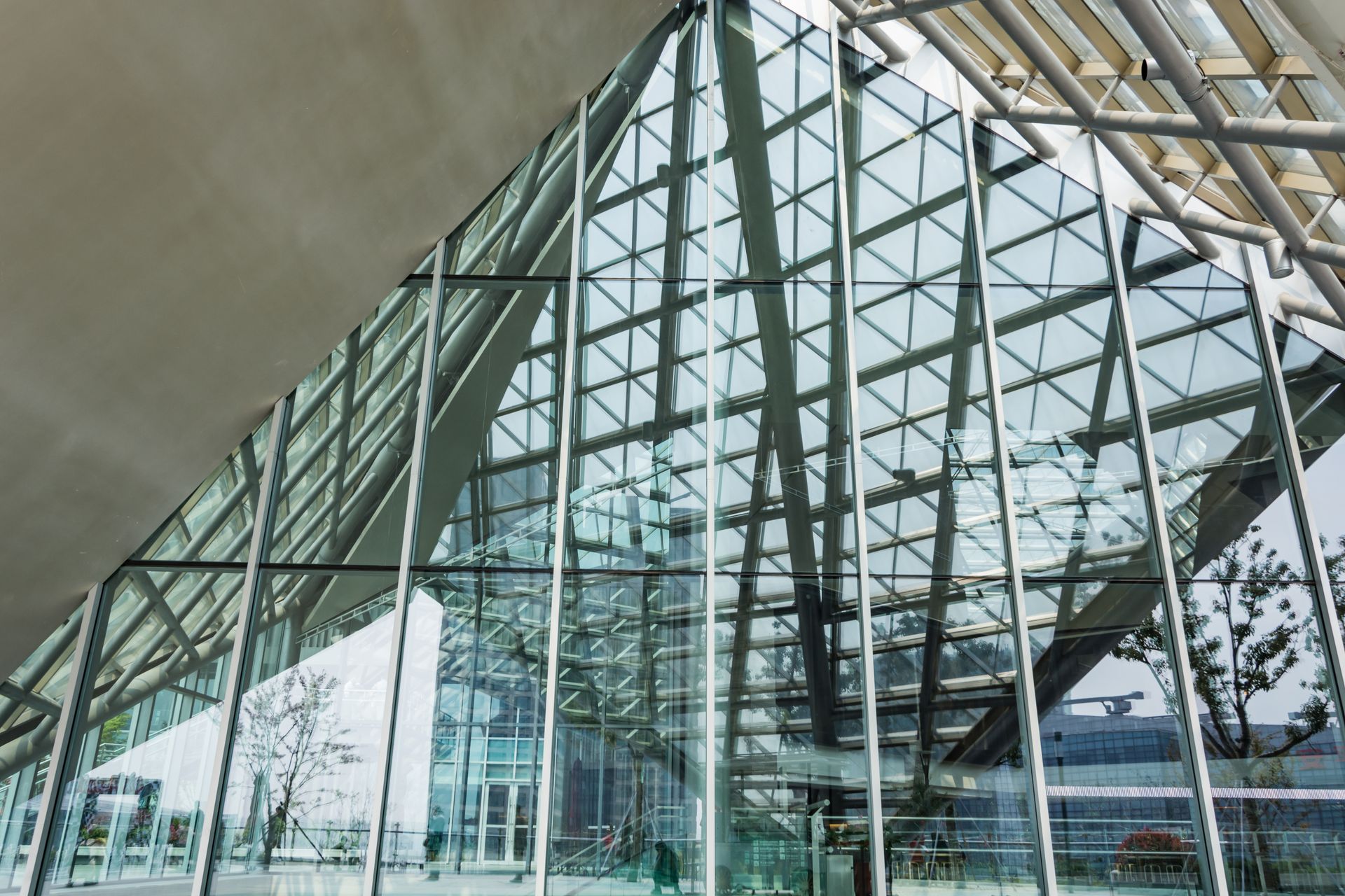 Modern glass atrium with steel beams and reflections in a bright architectural interior