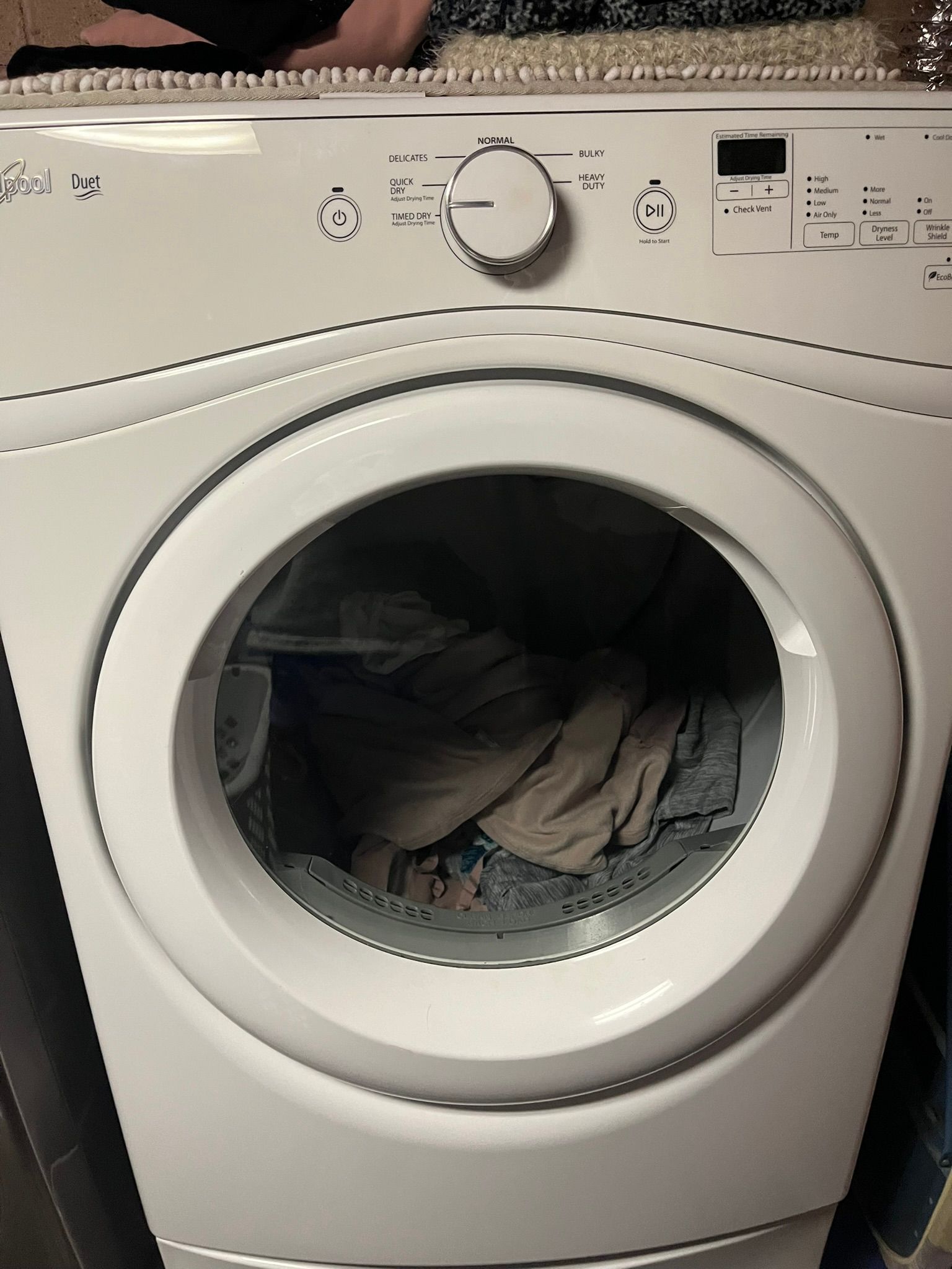 A white washer and dryer with clothes in it