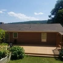 A brick house with a wooden deck in front of it.
