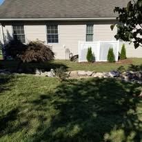 A house with a white fence and a lot of grass in front of it.
