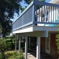 A balcony with a blue railing on top of a house.