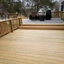A wooden deck with a table and chairs on it.