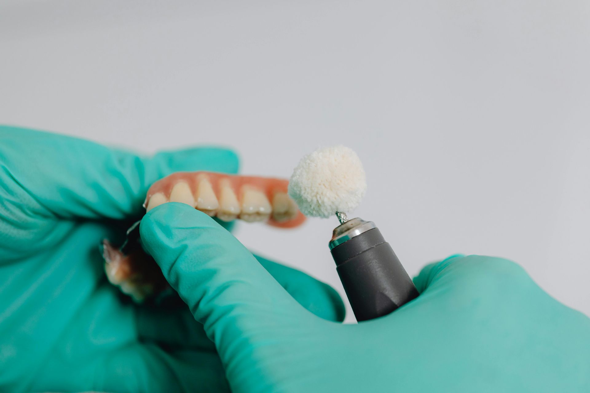 Dentist polishing a denture