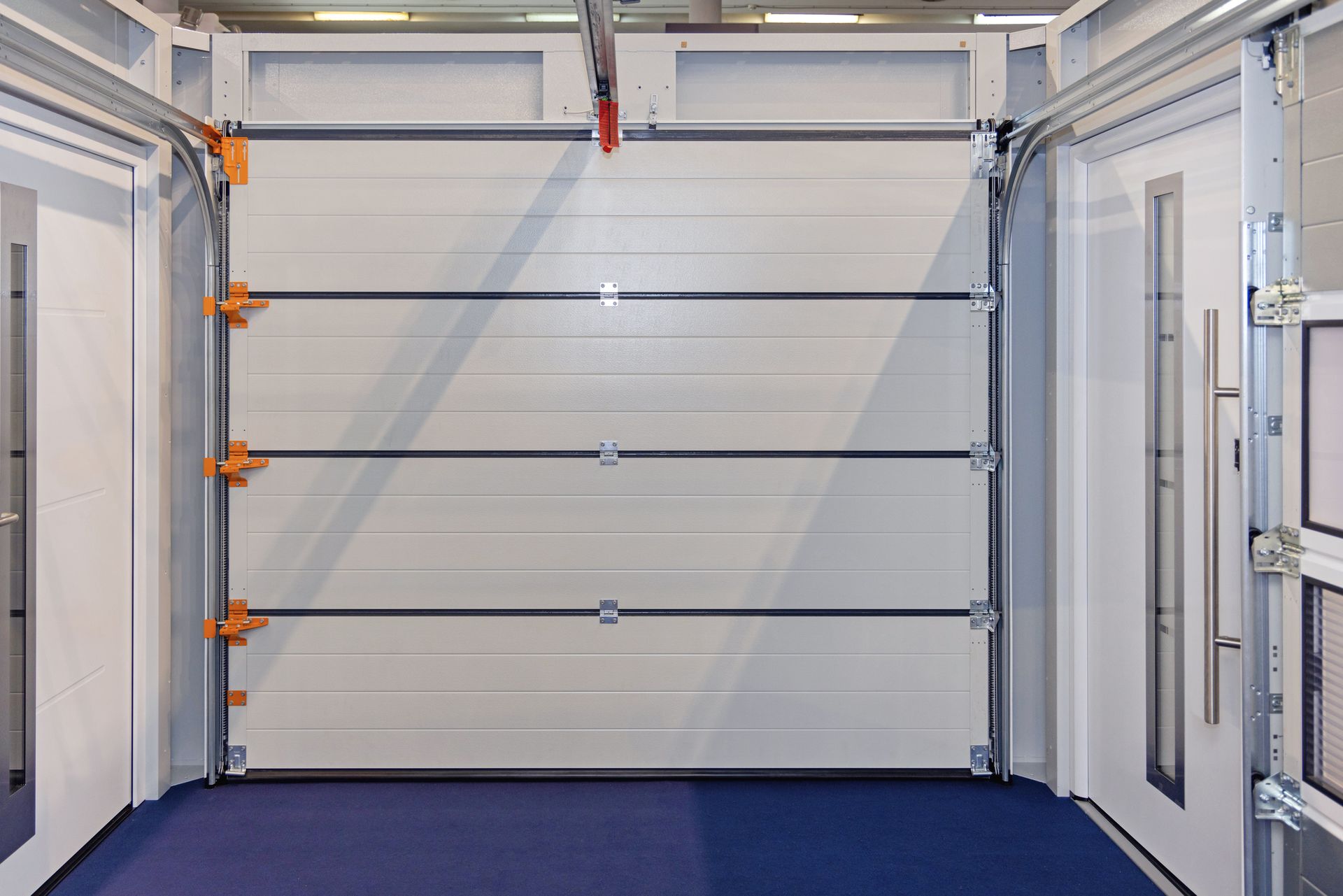Interior view of a white, sectional garage door with horizontal support bars, open.
